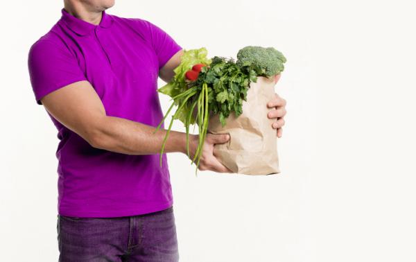 Un uomo trasporta delle verdure per una consegna a domicilio.