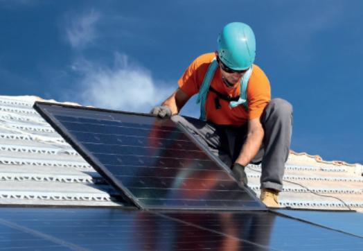 Un operaio sta montando un pannello solare su un tetto.